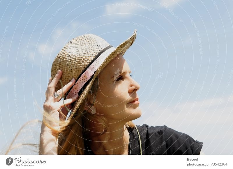 woman in a borsalino hat enjoying the summer sun on the coast surfer people blonde sea lifestyle portrait face poses attractive shore France europe