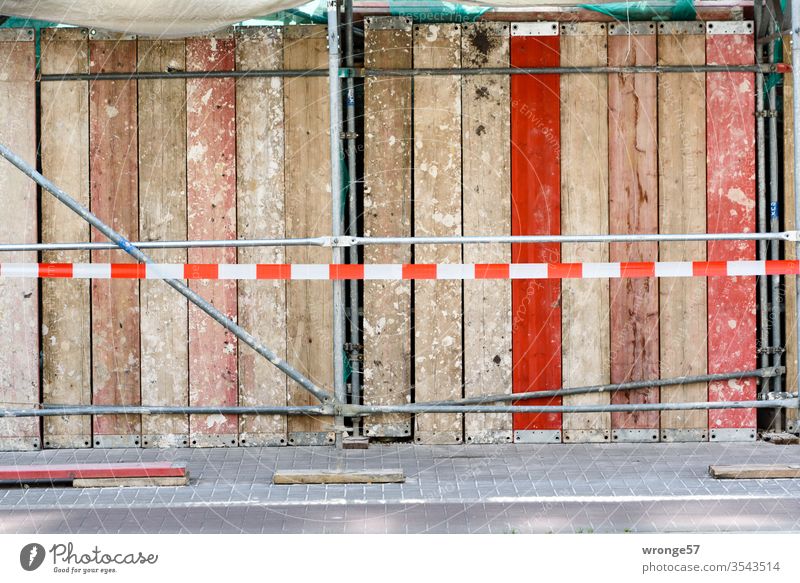 Construction site safety and scaffolding on a footpath Hoarding site fence construction site safety Armour Scaffold Scaffolding planks off barrier tape Safety