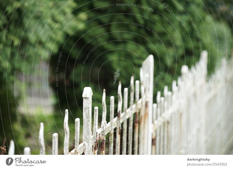 Garden with white metal fence and with rusty spots for fencing and security. Fence Safety dwell Break-in burglar protection Neighbouring rights Neighbor