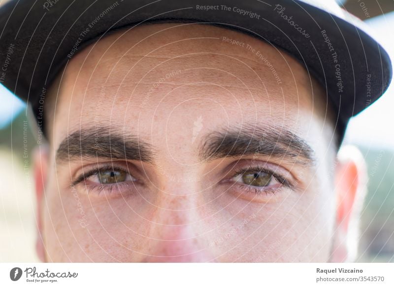 Close-up of the green eyes of a caucasian boy, with a cap. portrait look expensive iris pupil tabs foreground close up skin to transmit