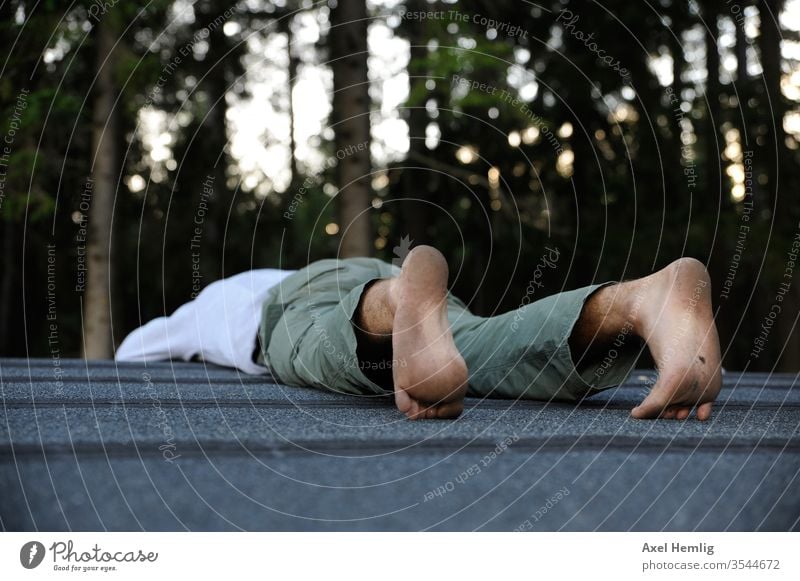 Man lies face down on a roof tranquillity Calm Be quiet! Exterior shot Relaxation Serene To be silent Loneliness calm Day stoic rest Idle Colour photo Swede