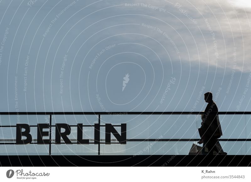 Man comes from shopping. Shopping Berlin stoop silhouette Back-light lettering Business Town Hotel Merchant Loft Window Sky German Clouds Room view Light