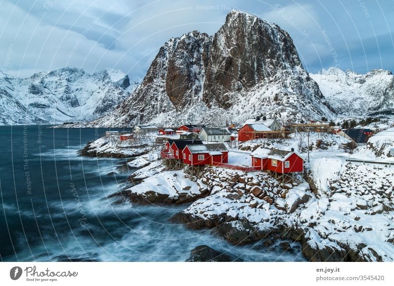 1.400 | small idyllic fishing village at the fjord in winter in front of snowy mountains Hamnöy Lofoten," Reine Winter Fishing village seascape blue hour