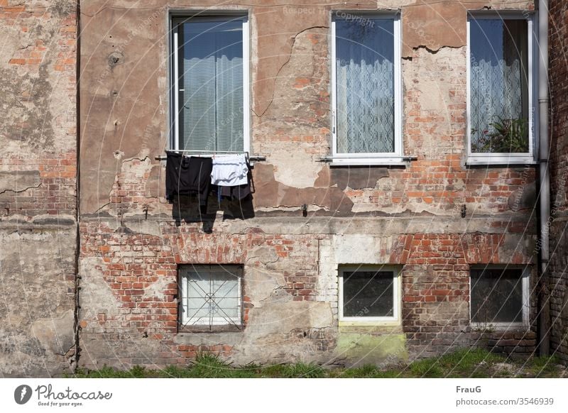 Old house and fresh laundry Building House (Residential Structure) Apartment Building Facade Plaster Brick Window curtains Tumble dryer Dry Laundry hung T-shirt