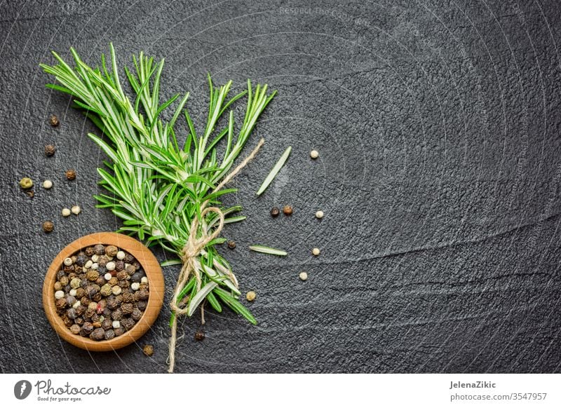 Spices and herbs over black stone table rosemary ingredient fresh spice raw organic cooking food green cuisine plant nature seasoning healthy herbal italian