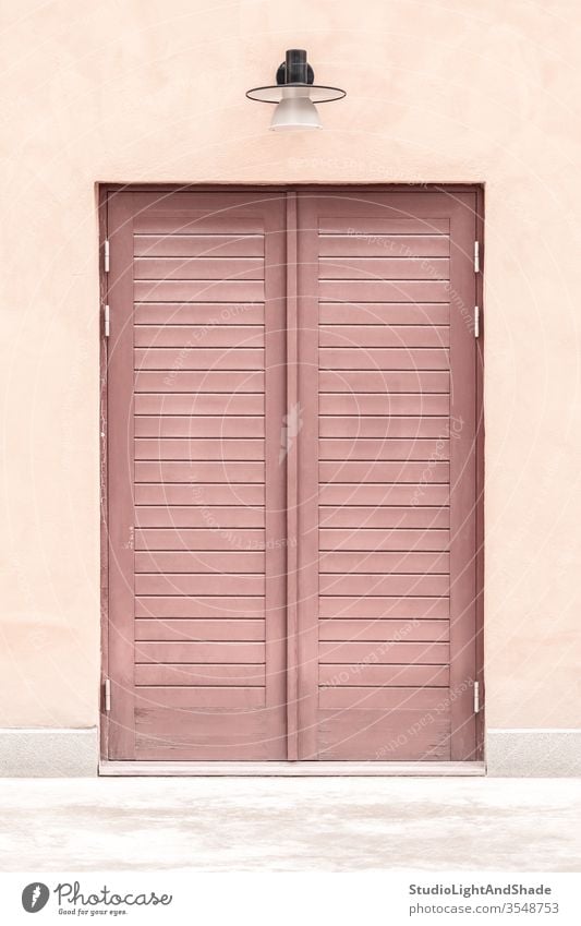 Pink building with a wooden door entrance pink red pastel closed house home lamp streetlamp streetlight exterior city town urban Europe European Stockholm