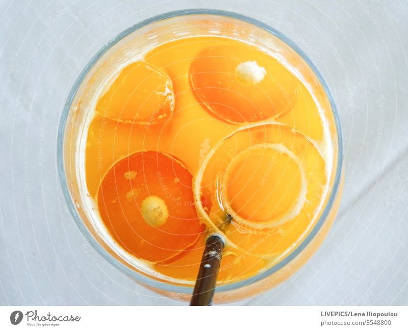 an orange juice in a glas, looks like a face Orange copy space eyes ice cubes light background mouth orange-slices nature freshness liquid drink refreshing