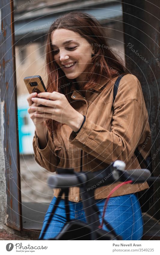 Young woman looking at smartphone on the street city life lifestyle urban beautiful communication connection device europe exterior gadget internet model wood