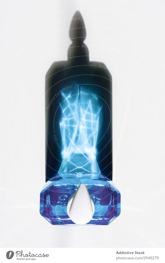 Soap bottle with blue liquid creating majestic reflections shadow contrast drop intensive color glow effect deep x ray beam dispenser geometry fraction vivid
