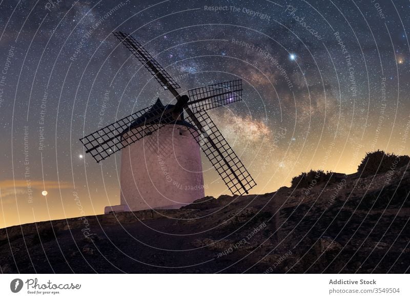 Rocky hill with dutch windmill at starry night landscape milky way mountain rock sky spectacular dark scenery magnificent evening amazing scenic galaxy universe