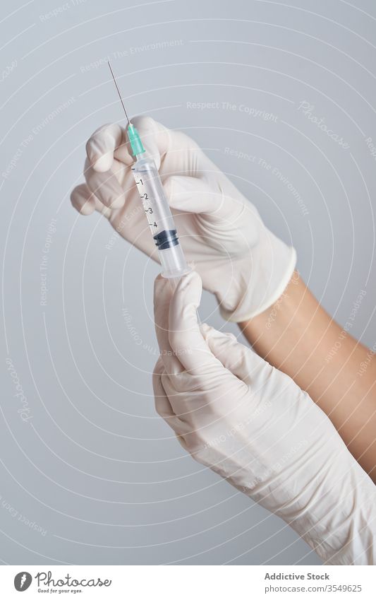 Close-up of hands holding a syringe sterile injection medicine vaccine health care treat cure medical glove vaccination doctor needle nurse isolated treatment