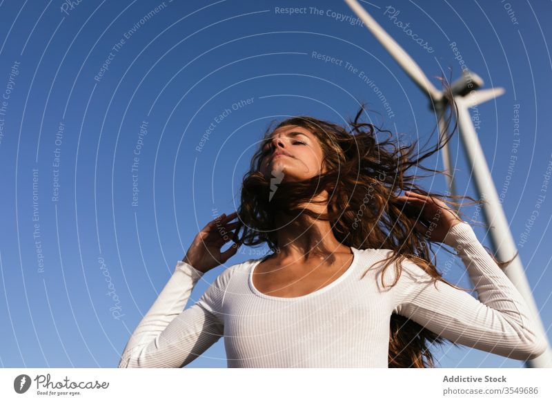 Tender female dancing alone near wind farm on sunny field woman dance countryside sensual nature ecology slim style alternative windmill energy move model