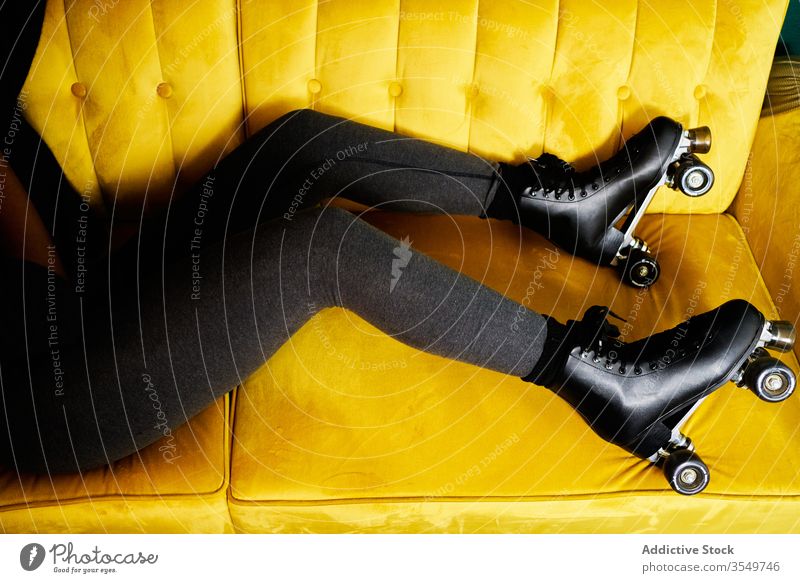 Anonymous woman in roller skates lying on sofa stay home activity colorful young black female african american concept relax restriction coronavirus isolation