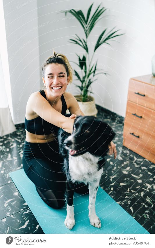Woman having fun with dog during yoga session at home woman smile companion friend hug together owner female purebred practice pet animal lifestyle canine