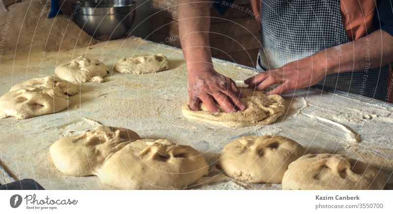 Close up male hands rolling out dough to make traditional ramadan bread baker bakery cook food meal delicious tasty turkey turkish muslim middle east cuisine