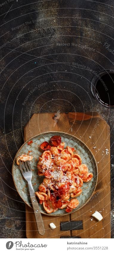 South italian  pasta orecchiette with tomato sauce and cacioricotta cheese apulia tomatoes sugo top view dark copy space wooden cooked cuisine diet dinner dish