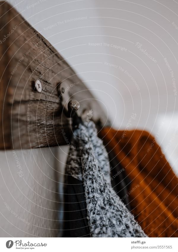 different coloured jackets hang on a wooden wardrobe with a strong depth of field coat hook garments Jacket Clothing Fashion Style Close-up Checkmark Hang up