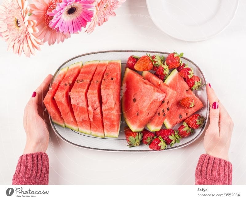 Watermelon slices on tray on white wooden table watermelon summer strawberries ceramic hands pink female fresh snack flowers delicious beautiful bright eat food