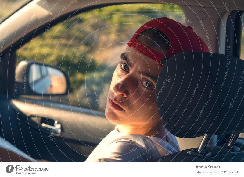 Portrait of a young man sitting in a car Baseball cap already Boy (child) Car Easygoing Caucasian Self-confident Driving voyage Lifestyle Looking Manly Model