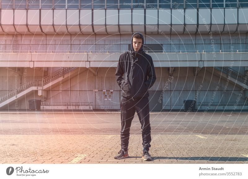 portrait of a young man with black hoodie adolescent architecture beautiful boy building casual caucasian confident eager lifestyle looking male model outdoor