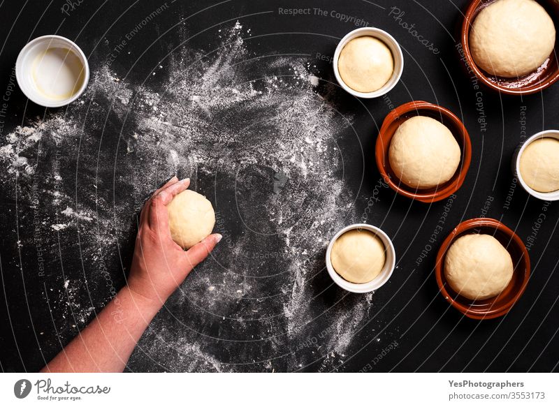 Baking bread buns top view. Woman shaping bread dough above view bake baked baker bakery baking black background ceramic trays comfort food consumerism cook