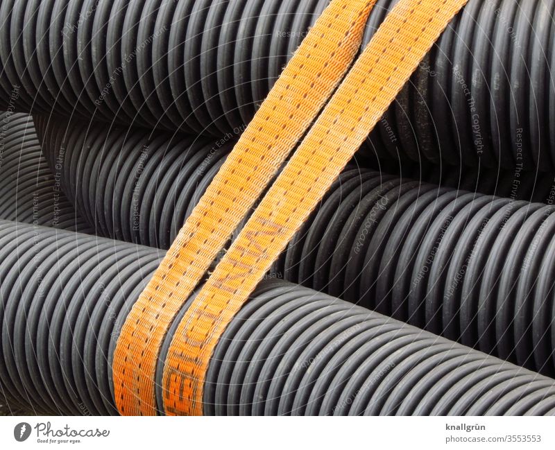 Several drainage pipes held together by a double brown belt reeds at the same time Belt Drainage pipes Detail Colour photo Black Gray Brown groove Pattern