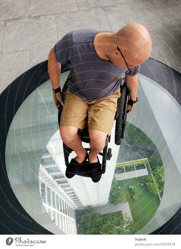 Seen from above. Wheelchair user on a glass platform wheelchair users Mobility Human being Independence Healthy Colour photo Lifestyle Hope Adventure luck