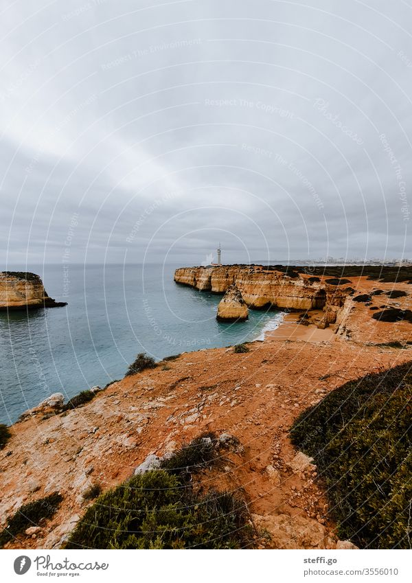 View over a bay in the Algarve with rocky coast and lighthouse Ferragudo Rock Wall of rock Rocky coastline Coast Lighthouse Ocean Bay Exterior shot Colour photo