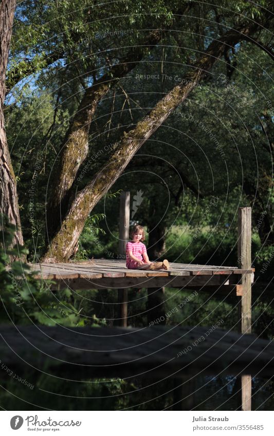 Toddler sitting on a catwalk between trees Footbridge Saale Franconia wood Willow tree River Plant Nature Water Wooden boards girl Sit leaves Gorgeous natural