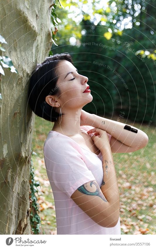 woman charging batteries in the middle of nature girl tattoo recharging style reload tree greeny nice beauty cool hipster cute dark hair young lifestyle people