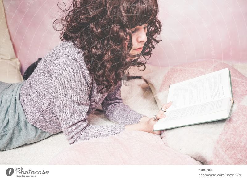 Young brunette woman reading a book in her bedroom student tired relax learn study home at home enjoy culture leisure pretty pink cute beautiful beautiful woman