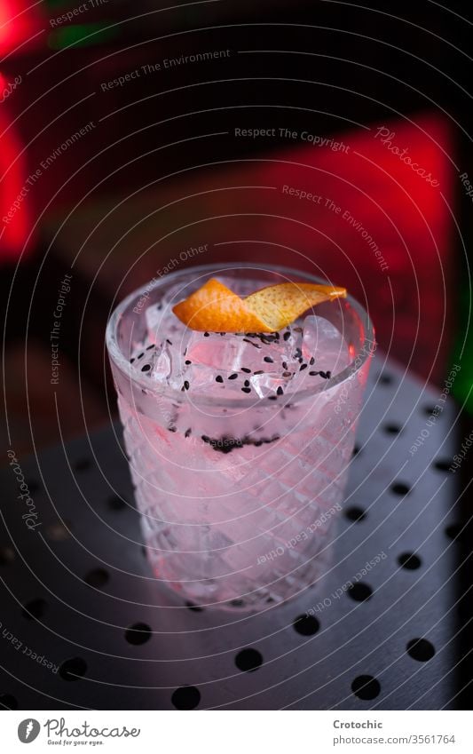 Glass with a white cocktail served on a metallic table seeds decoration red sweet ice vertical light neon bar beverage glass alcohol alcoholic drink club juice