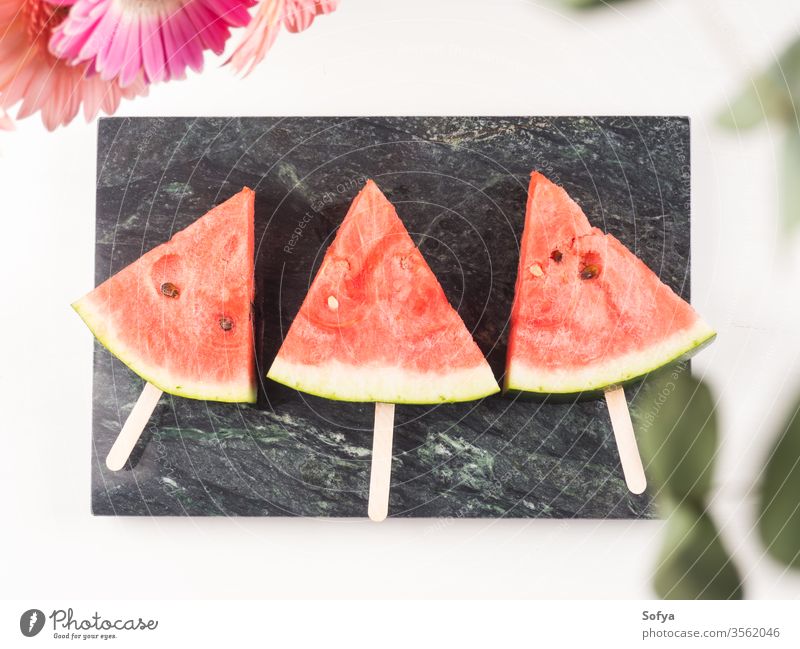 Watermelon slice popsicles on marble tray watermelon summer slices pink white wooden table fresh snack berries flowers delicious beautiful bright eat food sweet