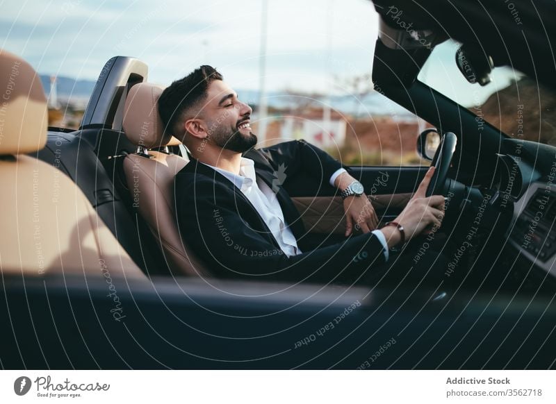 Attractive businessman with convertible car automobile person people young driver traffic vehicle screen assistance fashion cruise purchase suit road technology