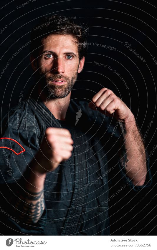 Strong man standing in defensive fighting stance martial fist defense confident strong serious portrait power determine adult pose exercise training combat