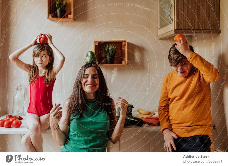 Mother and children obsessed with vegetables mother pepper pray concept kitchen diet healthy colorful home cozy teen kid girl boy sibling woman daughter son