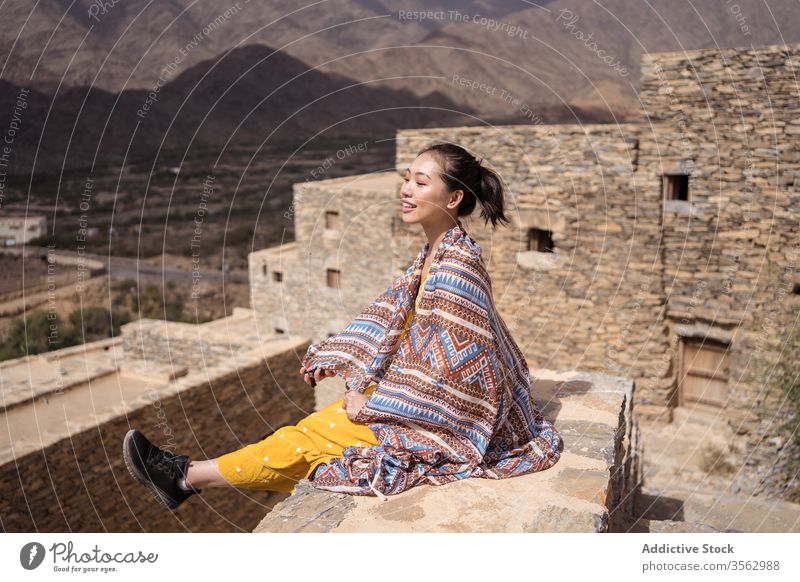 Woman near entrance of tower while walking along ancient sight woman sightseeing doorway building stone historic stair ruin rest heritage sunny architecture