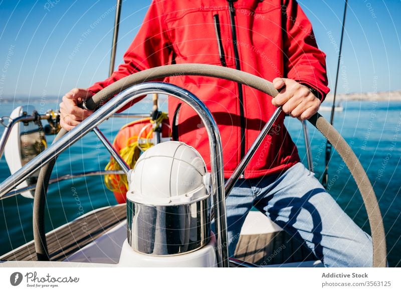 Anonymous man sailing on boat steering wheel helm sea adventure summer activity modern vessel travel transport water trip journey lifestyle ocean male ship