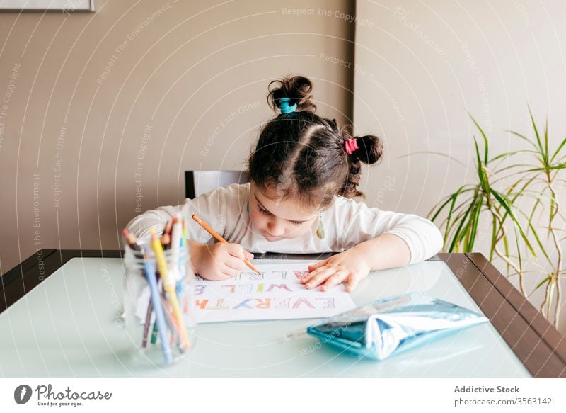 Concentrated little girl drawing with pencil at home table picture kid concentrate develop preschool paint inspiration hobby child creative wooden focus art