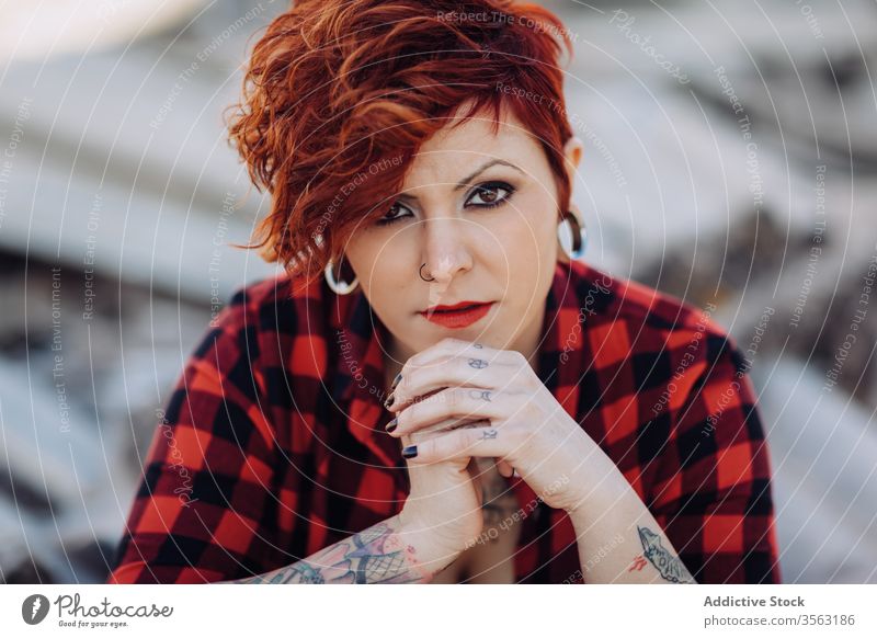 Confident tattooed woman looking at camera trendy independent informal style alternative confident young portrait modern street checkered shabby millennial
