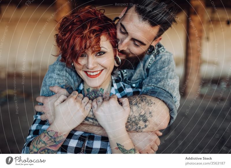 Happy young couple embracing near weathered building love embrace happy hipster street shabby together hug relationship tattoo boyfriend girlfriend affection