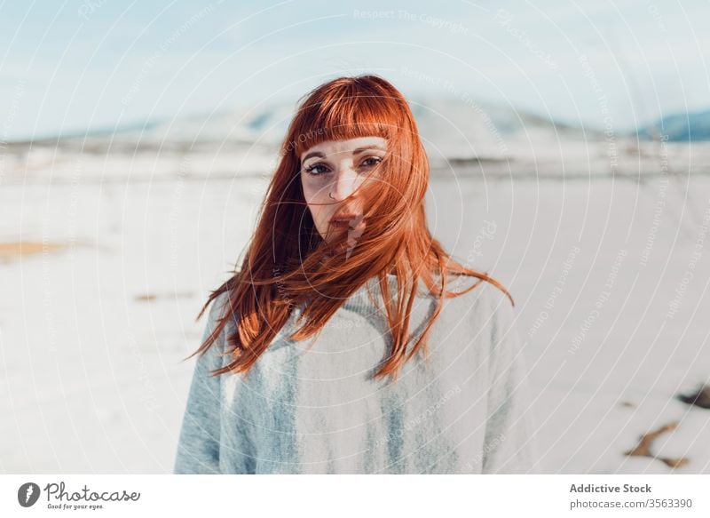 Sensual woman with red hair standing in snow field style trendy sensual redhead young nature attractive female ginger fashion modern charming elegant makeup