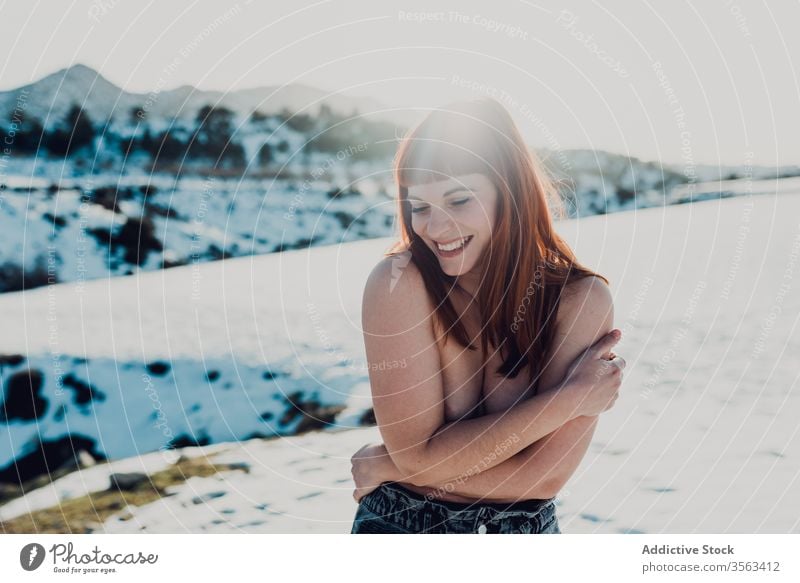 Cheerful topless woman in snowy field cheerful freedom nude naked cold young laugh countryside nature female smile happy joy lady positive fun winter red hair