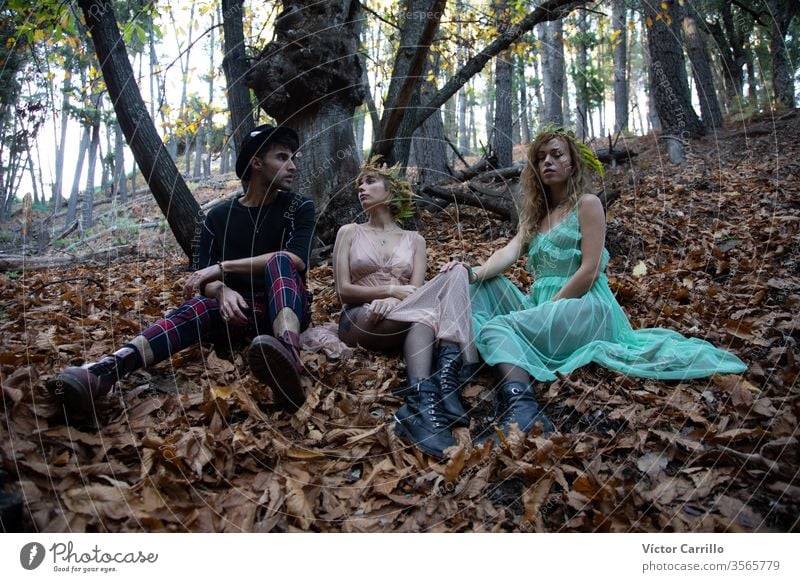 Three young bohemian friends in a forest natural pretty wild spiritual freedom person stylish green wild animals hair country romance dress beauty happy smile