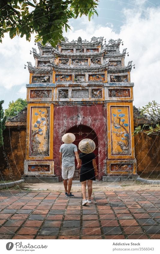 Traveling couple in love sightseeing during holiday travel buddhism temple arch walk shabby vietnam asia boyfriend girlfriend vacation summer pagoda tourist