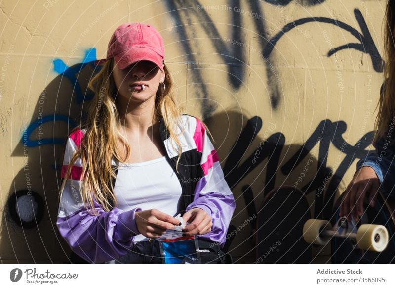 Confident female hipster smoking on street smoke woman skateboard graffiti millennial confident rebel girlfriend skater street style city building character