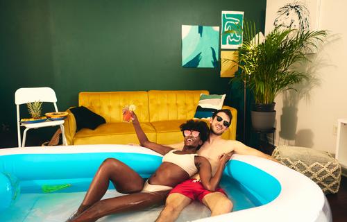 Content multiethnic couple resting in inflatable pool party stay at home content having fun self isolation in love social distancing water together multiracial