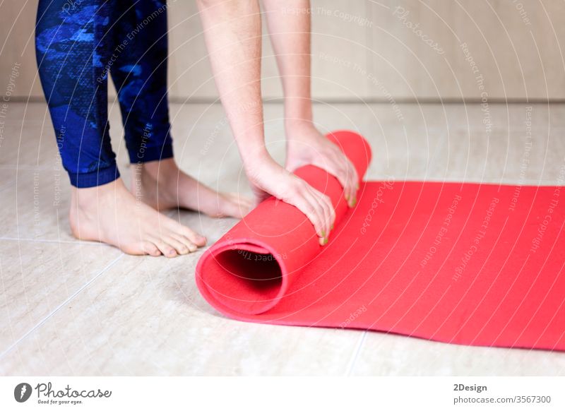 Close up of a Young girl rolling up the yoga mat exercise woman female fitness active body young beautiful class equipment lifestyle background relaxation