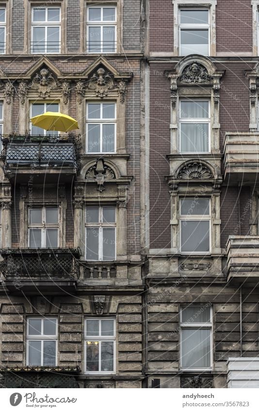 Yellow parasol on a balcony of an old building ancient apartment apartments architectural architecture balconies Berlin brick city cityscape color colorful