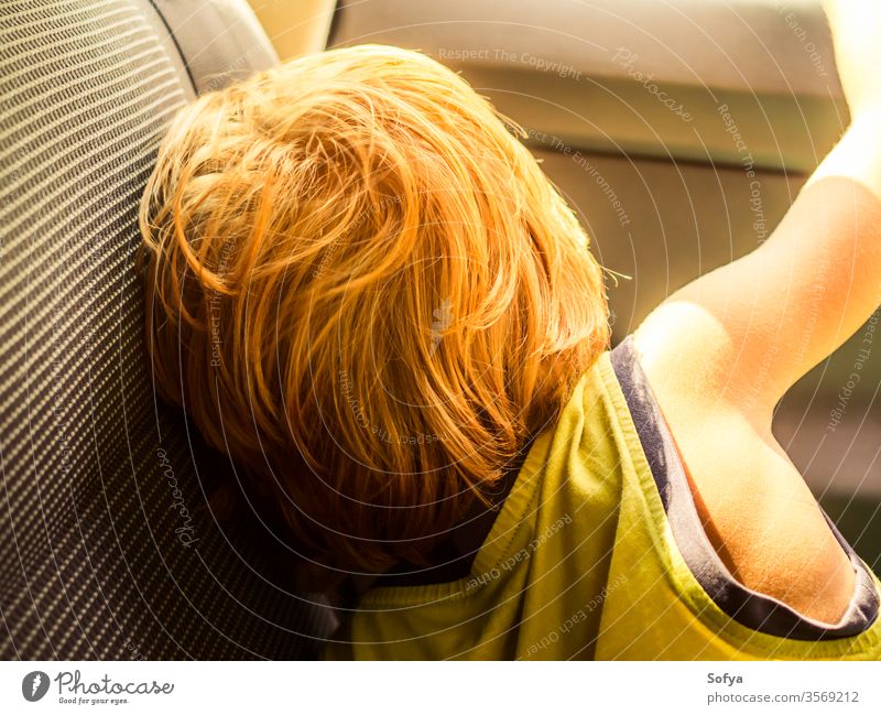 Little boy travelling in a car in summer little child enjoy sun sunny day light t-shirt yellow blonde caucasian kid vacation holiday natural young back tired